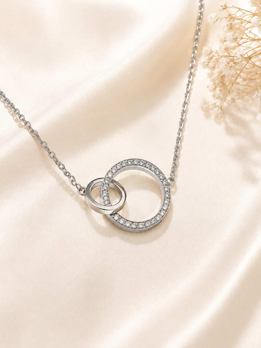 Collier double anneau argenté strass - vue à plat sur satin