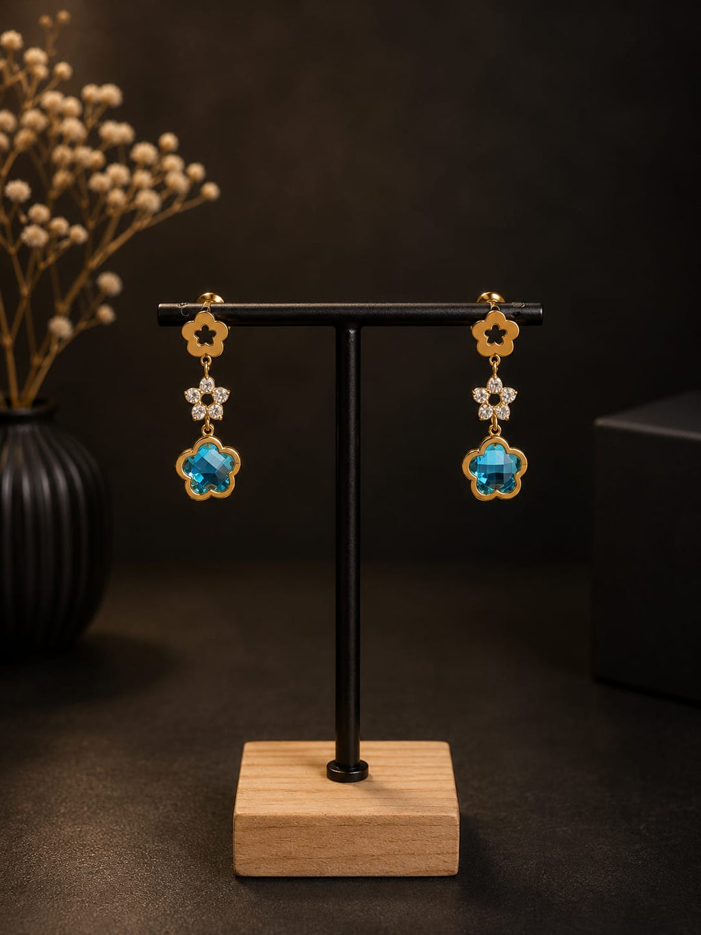 Boucles d'oreilles pendantes dorées fleurs cristal bleu - vue complète sur présentoir bois