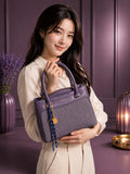 Sac à main Angelo violet et tweed porté par une femme